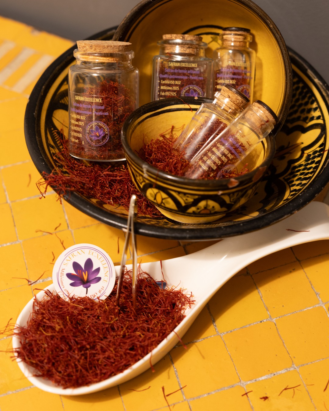 A spoon of saffron threads in front of Moroccan bowls